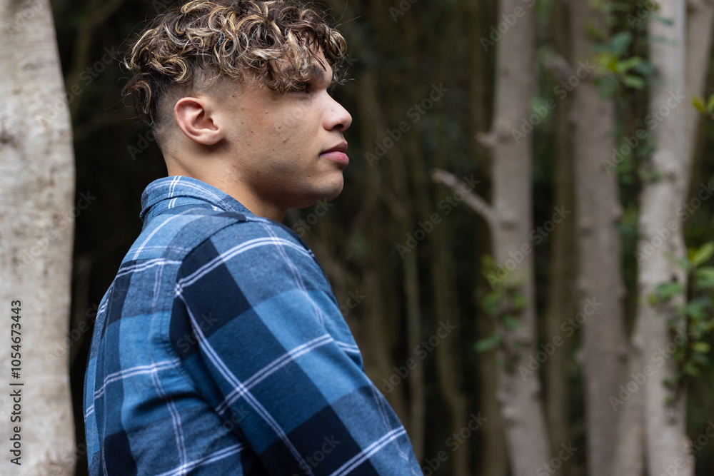 Young man in plaid shirt enjoying peaceful moment in forest Young man in plaid shirt enjoying peaceful moment in forest