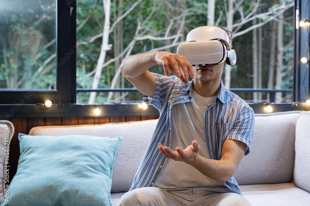 Christmas time, man using VR headset on sofa, exploring virtual world at home Christmas time, man using VR headset on sofa, exploring virtual world at home