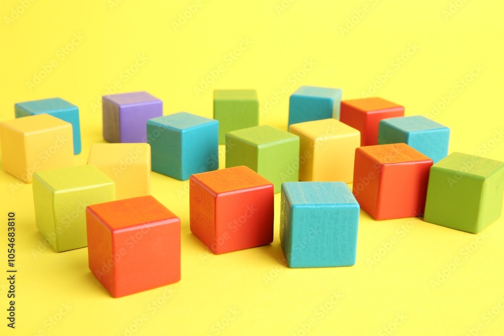 Many wooden colorful cubes on yellow background Many wooden colorful cubes on yellow background