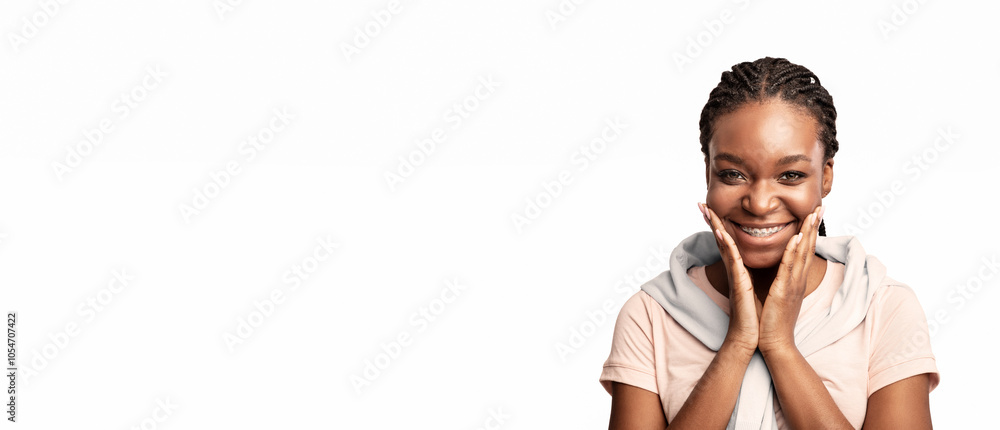 Orthodontics. Pretty African Lady With Braces On Teeth Posing Touching Face Smiling To Camera Over White Background In Studio Orthodontics. Pretty African Lady With Braces On Teeth Posing Touching Face Smiling To Camera Over White Background In Studio