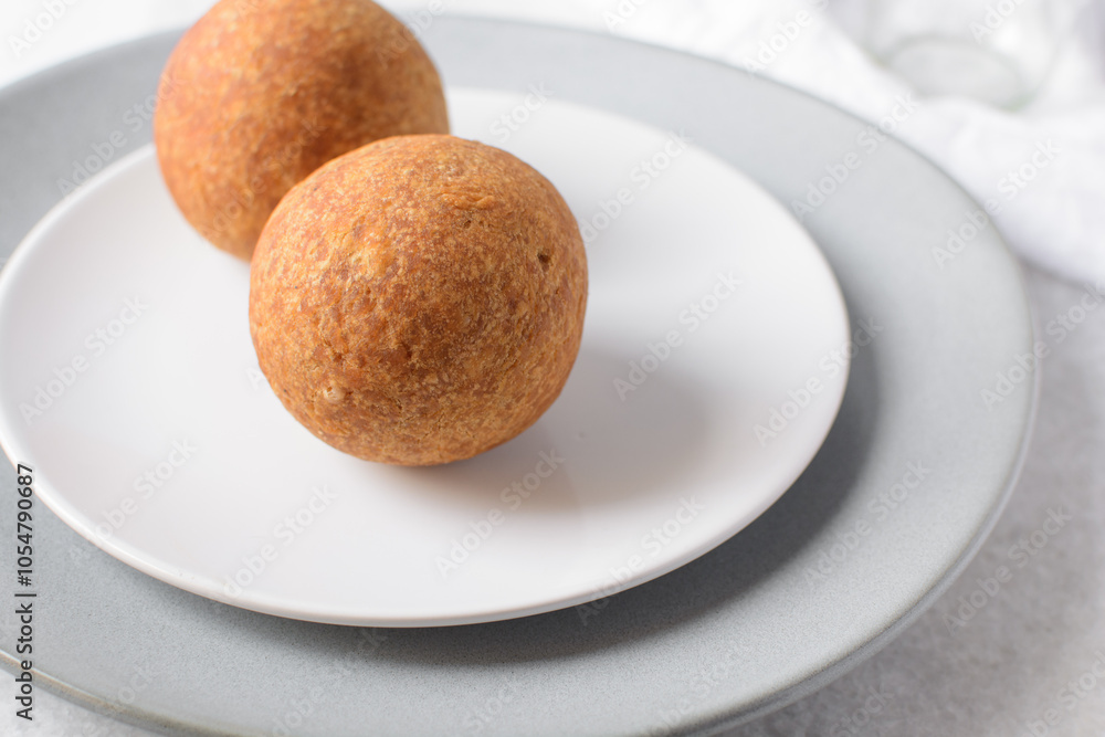 homemade nigerian egg roll in a white ceramic plate, freshly made african egg roll on a white plate, egg wrapped in fried dough homemade nigerian egg roll in a white ceramic plate, freshly made african egg roll on a white plate, egg wrapped in fried dough