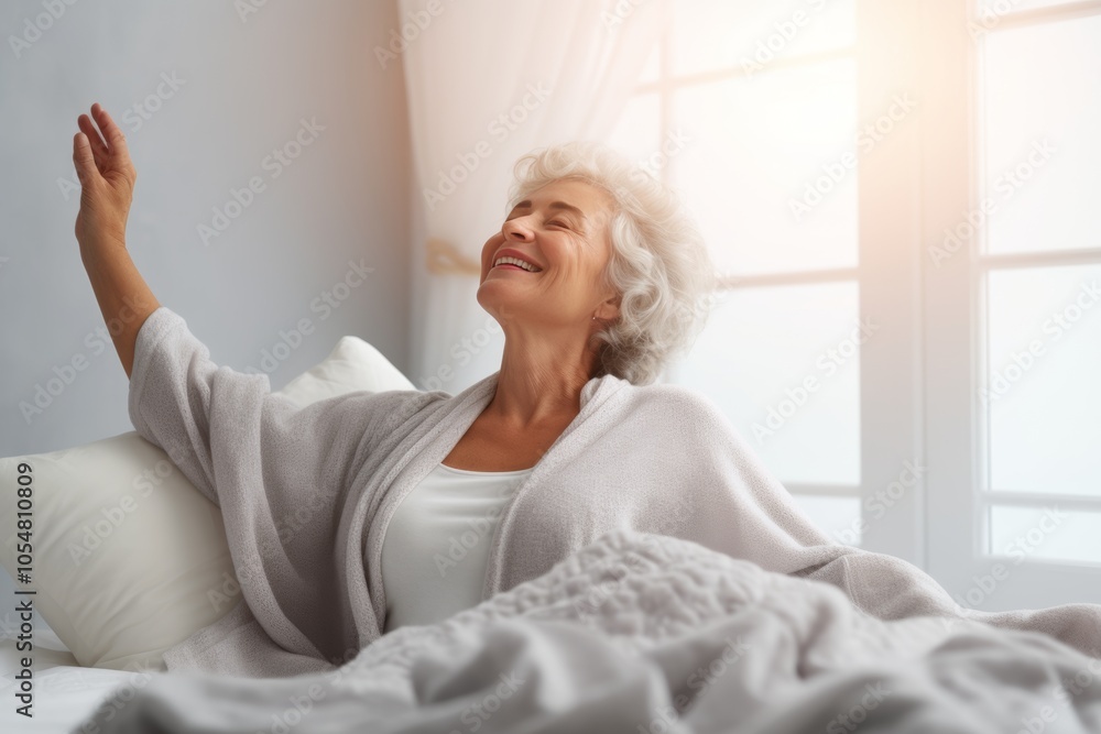 A happy mature woman stretching in a sunlit bedroom to embrace a fresh morning A happy mature woman stretching in a sunlit bedroom to embrace a fresh morning