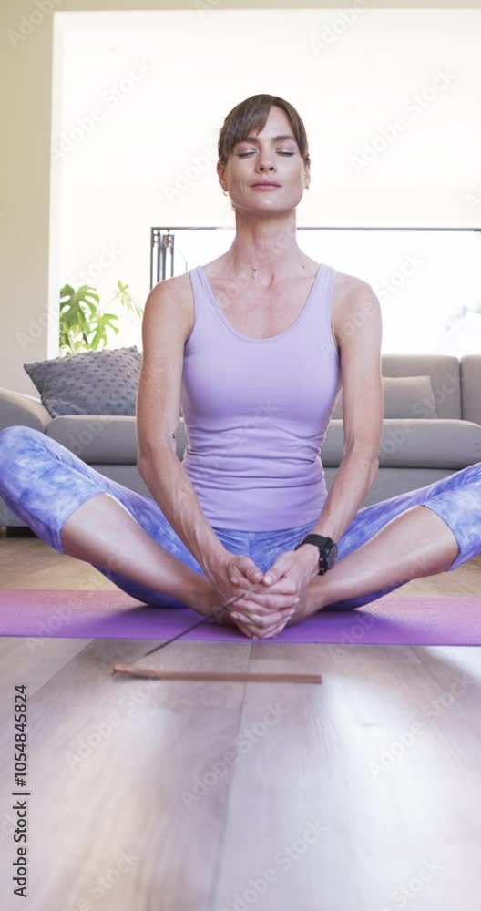 Vertical video: Caucasian woman practicing yoga at home Vertical video: Caucasian woman practicing yoga at home