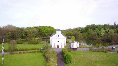 Exterior Facade Of Leaning Church Of St Peter Of Alcantara With Tower Clock In Karvina, Czech Republic. drone approach photo