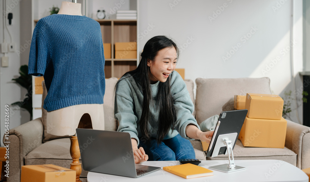 Successful fashion designer. Attractive woman with smile while standing in workshop. Beautiful owner woman working and holds tablet, laptop Successful fashion designer. Attractive woman with smile while standing in workshop. Beautiful owner woman working and holds tablet, laptop