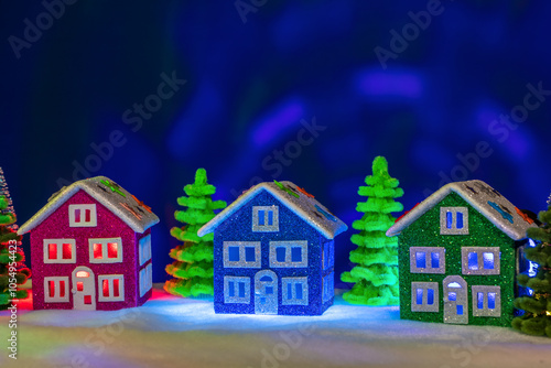 Wallpaper Mural A magical town with green, blue and pink houses with red and blue lights in the windows among colorful decorated Christmas trees Torontodigital.ca
