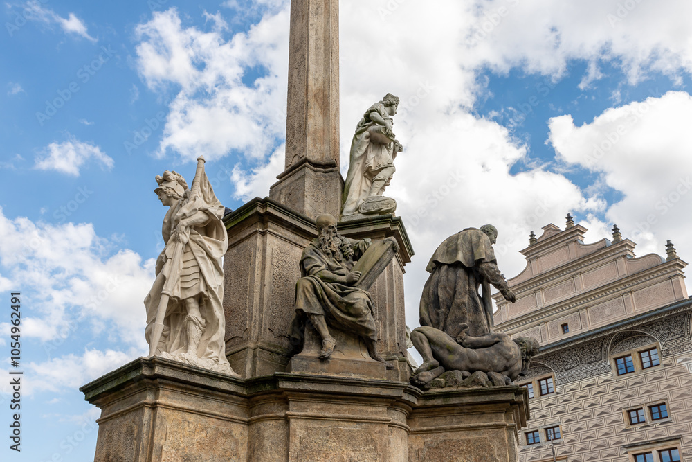 Obraz premium Group of sculptures at the bottom part of Marian Plague Column in garden on Hradcanska Square in Prague in Czech Republic