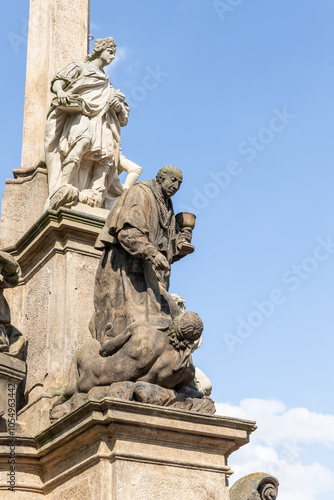 Group of the sculptures at the bottom of Marian Plague Column in the garden on Hradcanska Square in Prague in Czech Republic