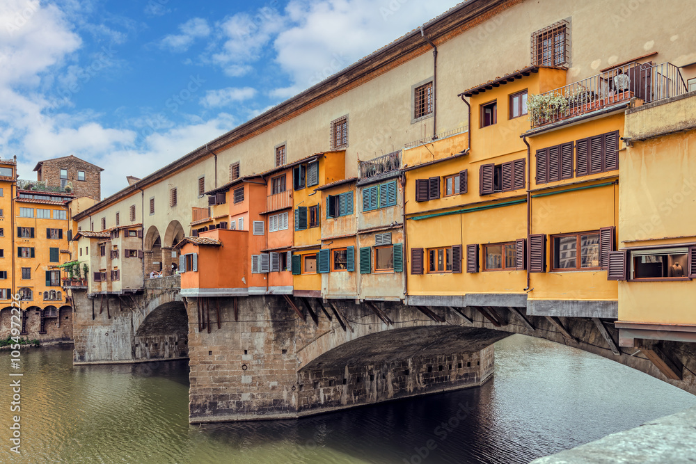 The Ponte Vecchio bridge in Florence showcases its colorful buildings and shops reflecting in the tranquil waters Arno river. The Ponte Vecchio bridge in Florence showcases its colorful buildings and shops reflecting in the tranquil waters Arno river.