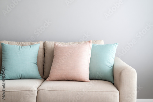 Cozy living room sofa with pastel cushions against a light gray wall in a bright space