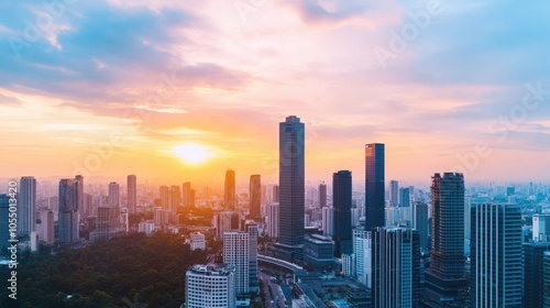 A stunning city skyline at sunset, showcasing modern skyscrapers with vibrant hues of orange and purple lighting up the sky.