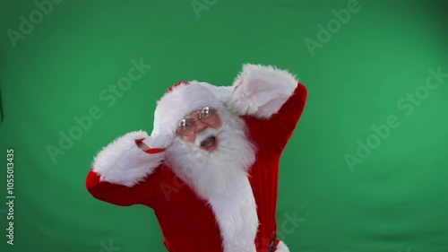 Shocked Santa screaming waving hands at Christmas discounts and sales standing on green background. Slow motion. photo