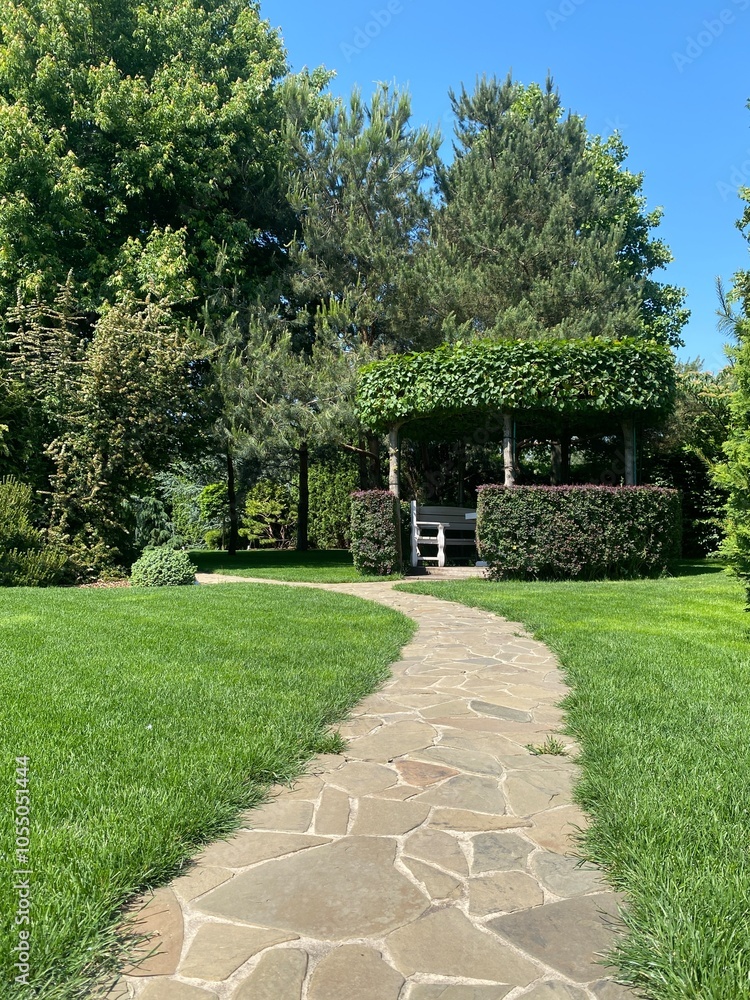 An excellent landscape solution includes an artificial pond and a pergola with plants, a green gazebo, a garden path paved with stone, An excellent landscape solution includes an artificial pond and a pergola with plants, a green gazebo, a garden path paved with stone,