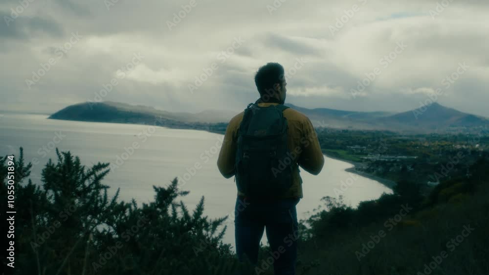 Man hiking, walking in the natural cliff, looking around, towards the sea, nature. Trekking with a backpack. Man hiking, walking in the natural cliff, looking around, towards the sea, nature. Trekking with a backpack.