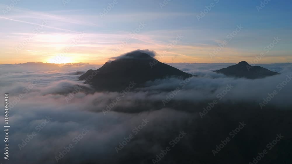 Aerial view on mountain peaks surrounded by sea of clouds at sunset. Trentino, Italy Aerial view on mountain peaks surrounded by sea of clouds at sunset. Trentino, Italy
