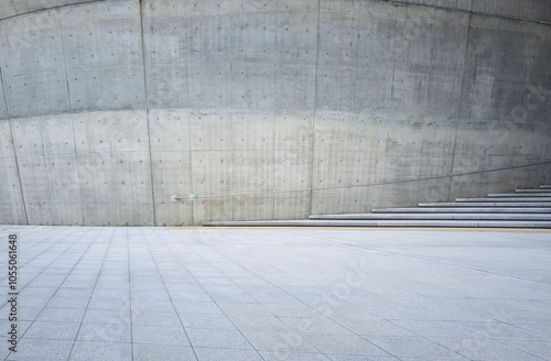 Empty concrete square with steps and curved wall