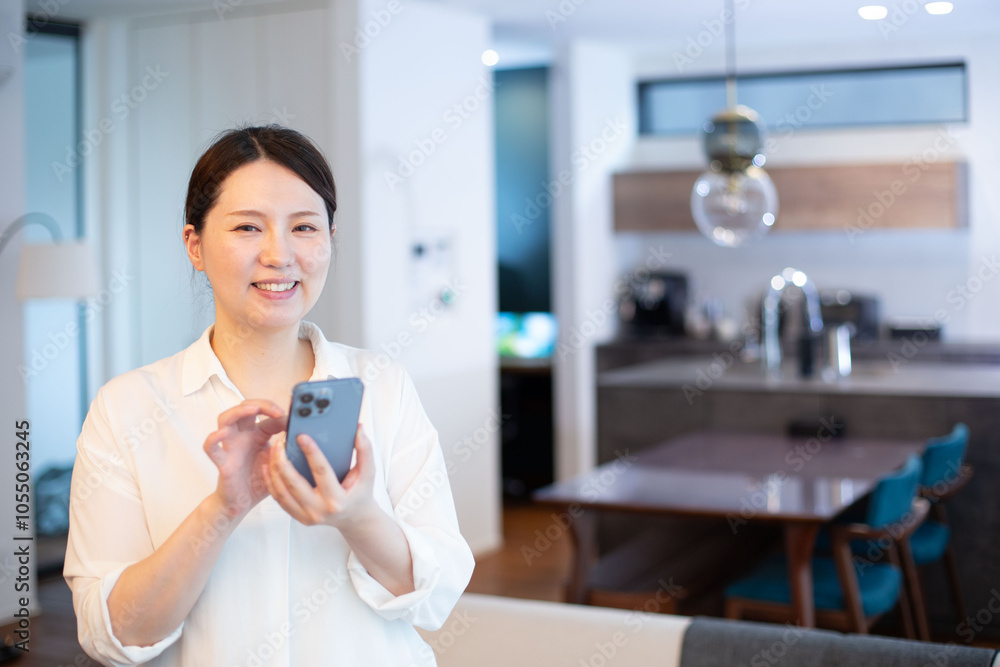 キッチンでスマホを見るミドル女性 キッチンでスマホを見るミドル女性