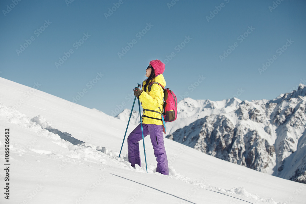 Woman in Colorful Winter Gear Climbing Snow-Covered Mountain in Sunny Day Woman in Colorful Winter Gear Climbing Snow-Covered Mountain in Sunny Day