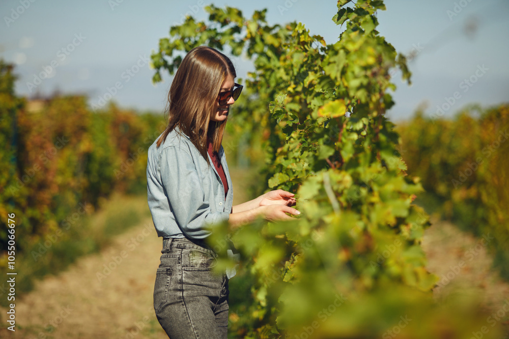 Woman Standing in Field Holding Vineyard Plant Woman Standing in Field Holding Vineyard Plant