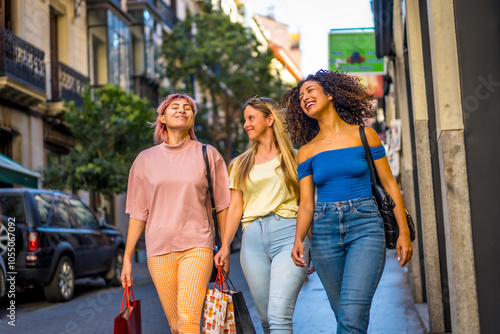 Happy friends shopping along a modern city