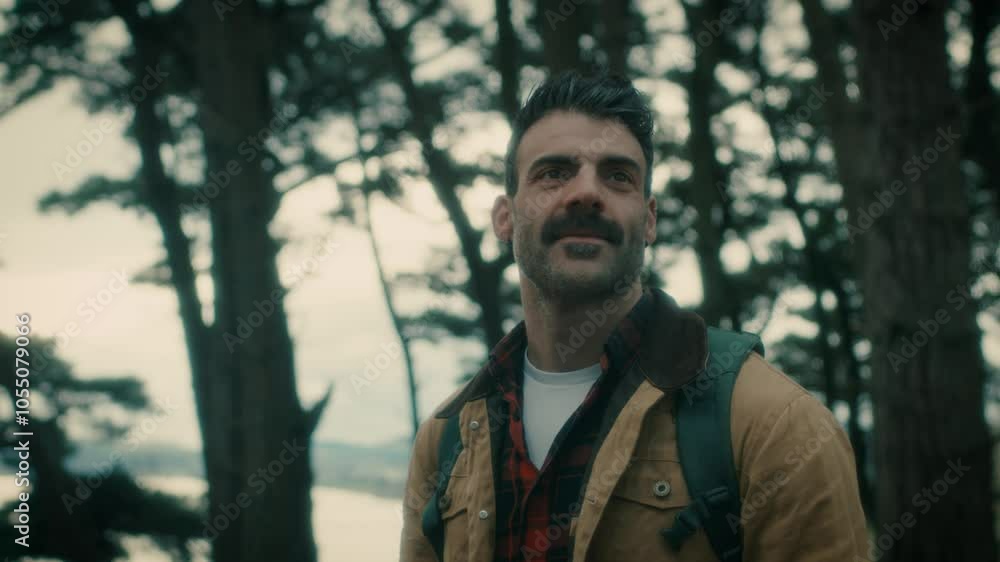 Man hiking, portrait in the natural forest, looking around, nature. Trekking with a backpack walks through the forest. Man hiking, portrait in the natural forest, looking around, nature. Trekking with a backpack walks through the forest.