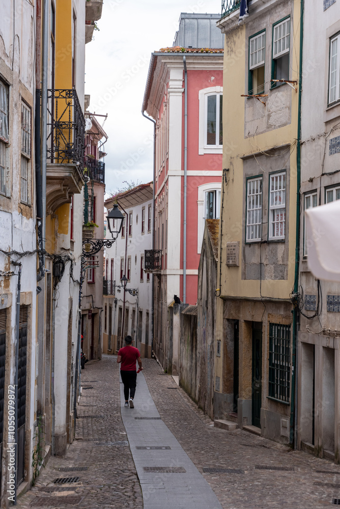 Obraz premium A young jogger in the picturesque street Joaquim Antonio de Aguiar in the historic center of Coimbra
