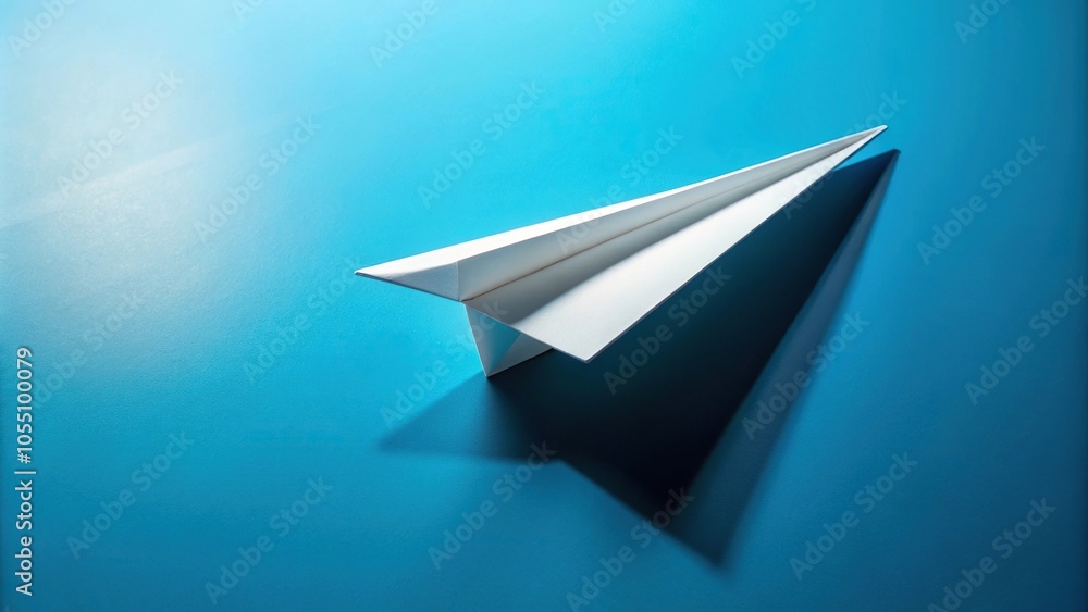 White paper airplane with shadow on blue background White paper airplane with shadow on blue background