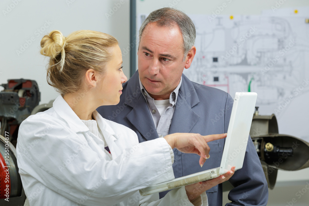 mechanic and apprentice looking at diagnostics results mechanic and apprentice looking at diagnostics results