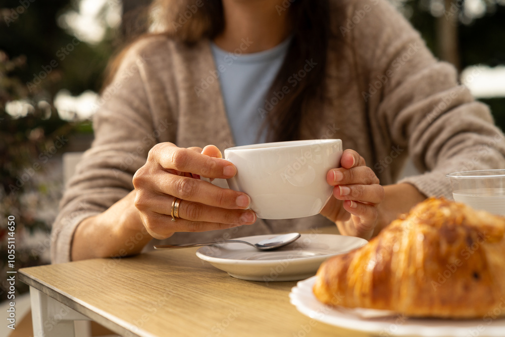 Woman drinking morning coffee of tea at breakfast table. Cup with copy space Woman drinking morning coffee of tea at breakfast table. Cup with copy space
