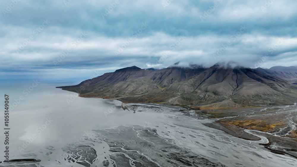 Fototapeta premium Aerial view of the rugged coastline and mountains in Svalbards unique natural landscape