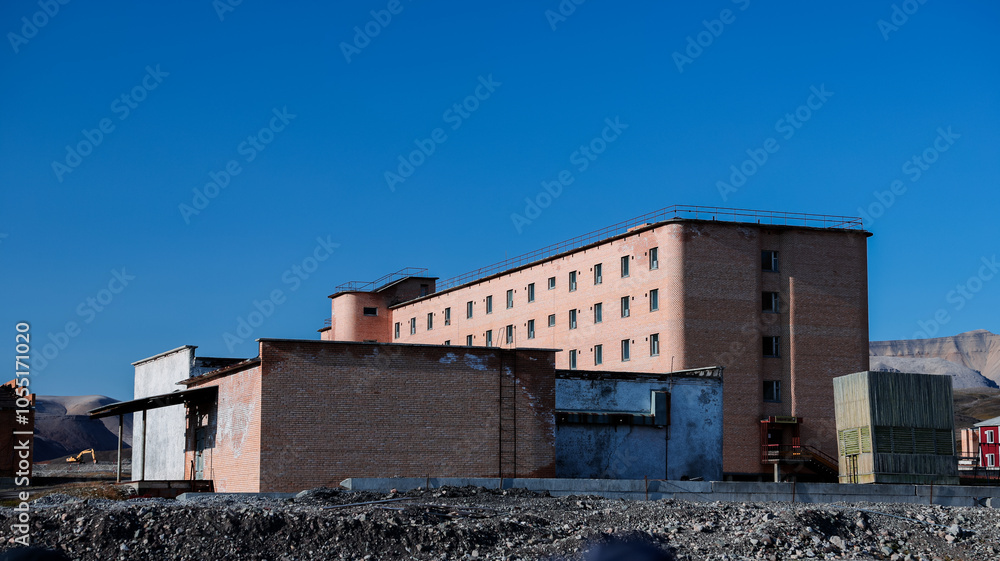 Fototapeta premium Exploring the abandoned Soviet mining town of Pyramiden in Svalbard on a clear sunny day