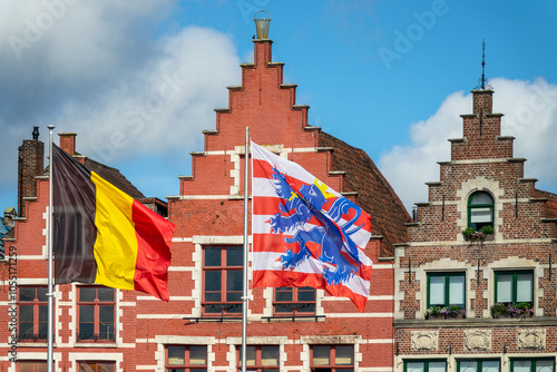 Flags of Belgium and of the city of Bruges with colorful houses on Bruges Markt (Market Square), Belgium