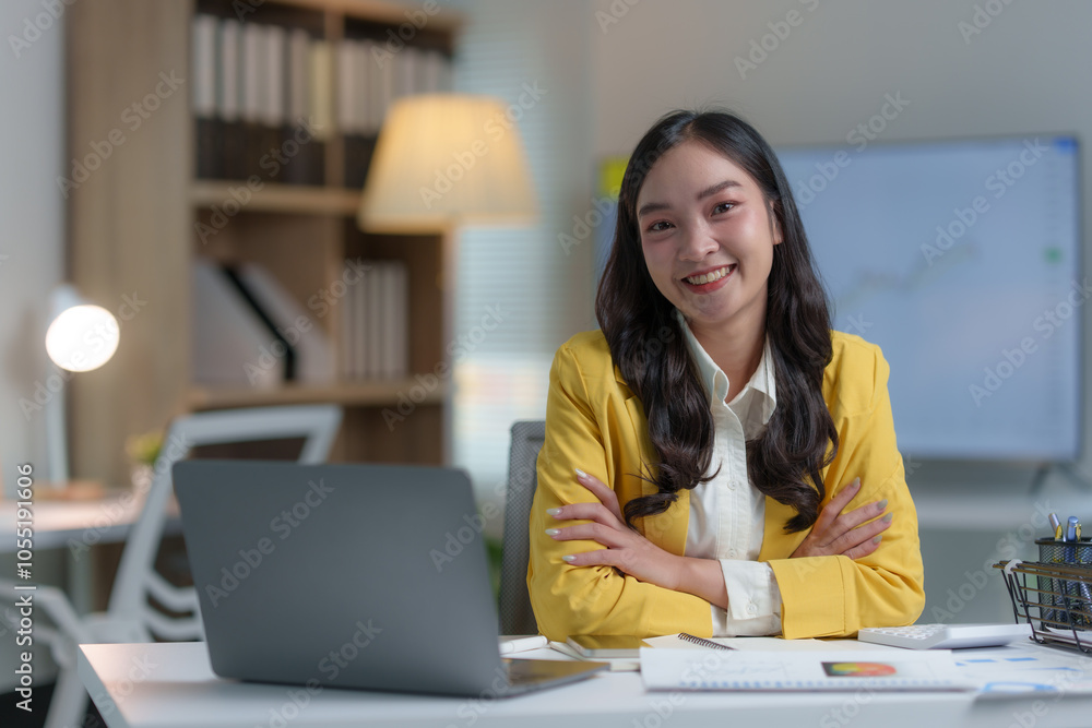 Young businesswoman, happy Asian secretary sitting smiling working online on laptop computer, financial documents Contacting customers at the desk with files in the corporate office. Young businesswoman, happy Asian secretary sitting smiling working online on laptop computer, financial documents Contacting customers at the desk with files in the corporate office.