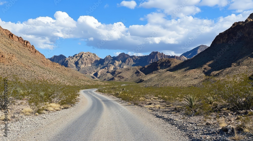 A remote road with a sharp curve leading into the mountains, surrounded by rugged, rocky terrain A remote road with a sharp curve leading into the mountains, surrounded by rugged, rocky terrain