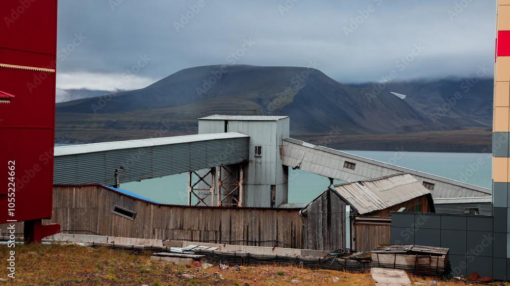Naklejka premium Unique architecture and landscape of Barentsburg showing industrial structures by the water