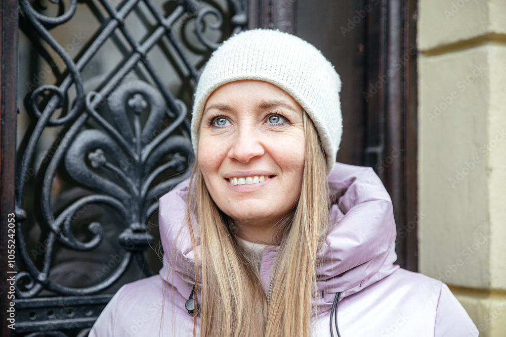 Smiling woman in winter attire standing by ornate door Smiling woman in winter attire standing by ornate door
