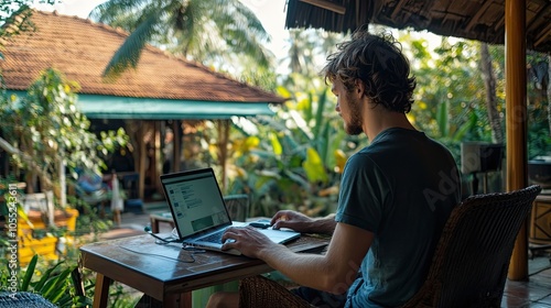 Man Working on Laptop in a Tropical Setting