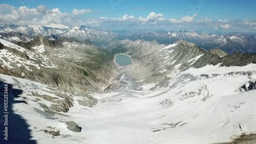 Drone shot of large white snowy glacier surface Oberaar glacier surrounded by mountain peaks, near Grimsel Pass in a beautiful winter day, Oberhaarhorn Gletscher, Switzerland photo