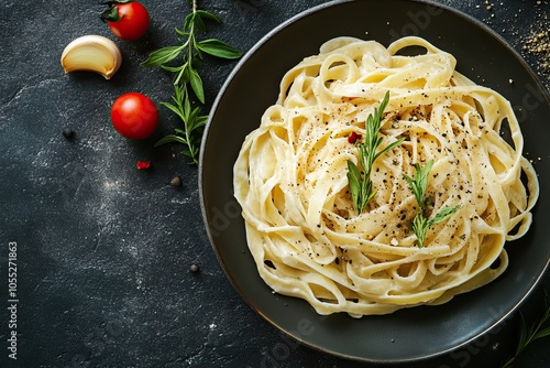 A bowl of creamy fettuccine alfredo pasta garnished with herbs, surrounded by fresh tomatoes and a rustic background.