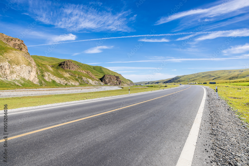Fototapeta premium Country road and green grassland with mountain natural scenery. Road trip.