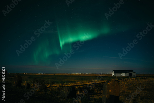 Dancing aurora borealis above Icelanding farm on the night sky