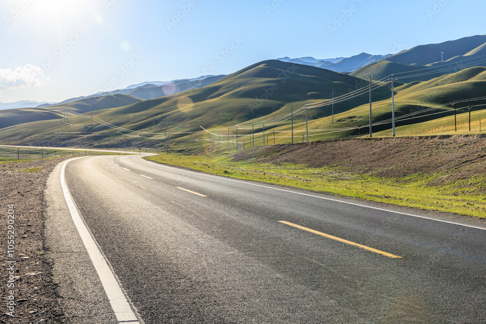 Naklejka premium Country road and green meadow with mountains nature landscape in the morning. Road trip.
