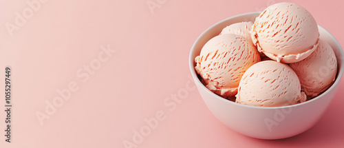 Delicious strawberry ice cream scoops served in a white bowl against a soft pink background, appealing and perfect for summer cravings.