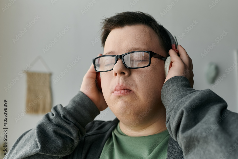 A young man with Down syndrome cherishes a peaceful moment while listening to music. A young man with Down syndrome cherishes a peaceful moment while listening to music.
