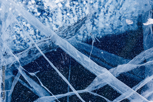 Texture blue transparent ice with cracks frozen Lake Baikal in winter, top view