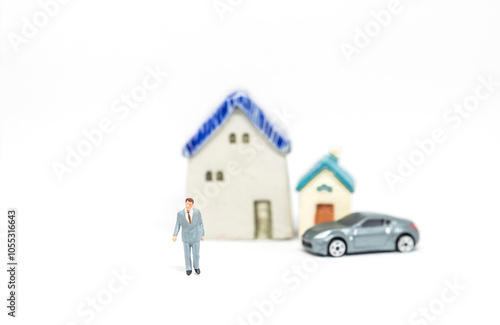 Miniature business man with car and house model on white background, life goal and archievement photo