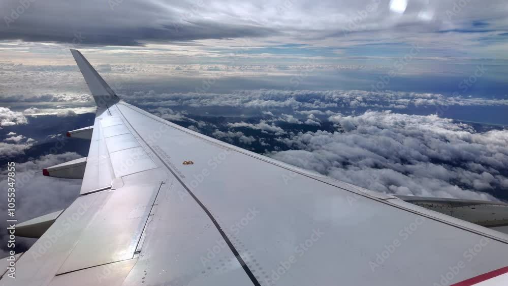 View from an airplane window of the aircraft wing in the clouds