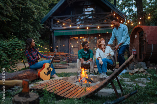 Friends enjoying a campfire in front of a cabin