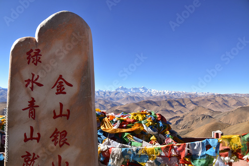 Buddhist Prayer Flags Flutter in the Wind with a Backdrop of Everest and the Himalayas photo