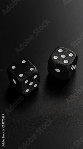 Two black dices on a black surface with white dots photo